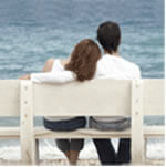 Pareja sentados mirando el mar